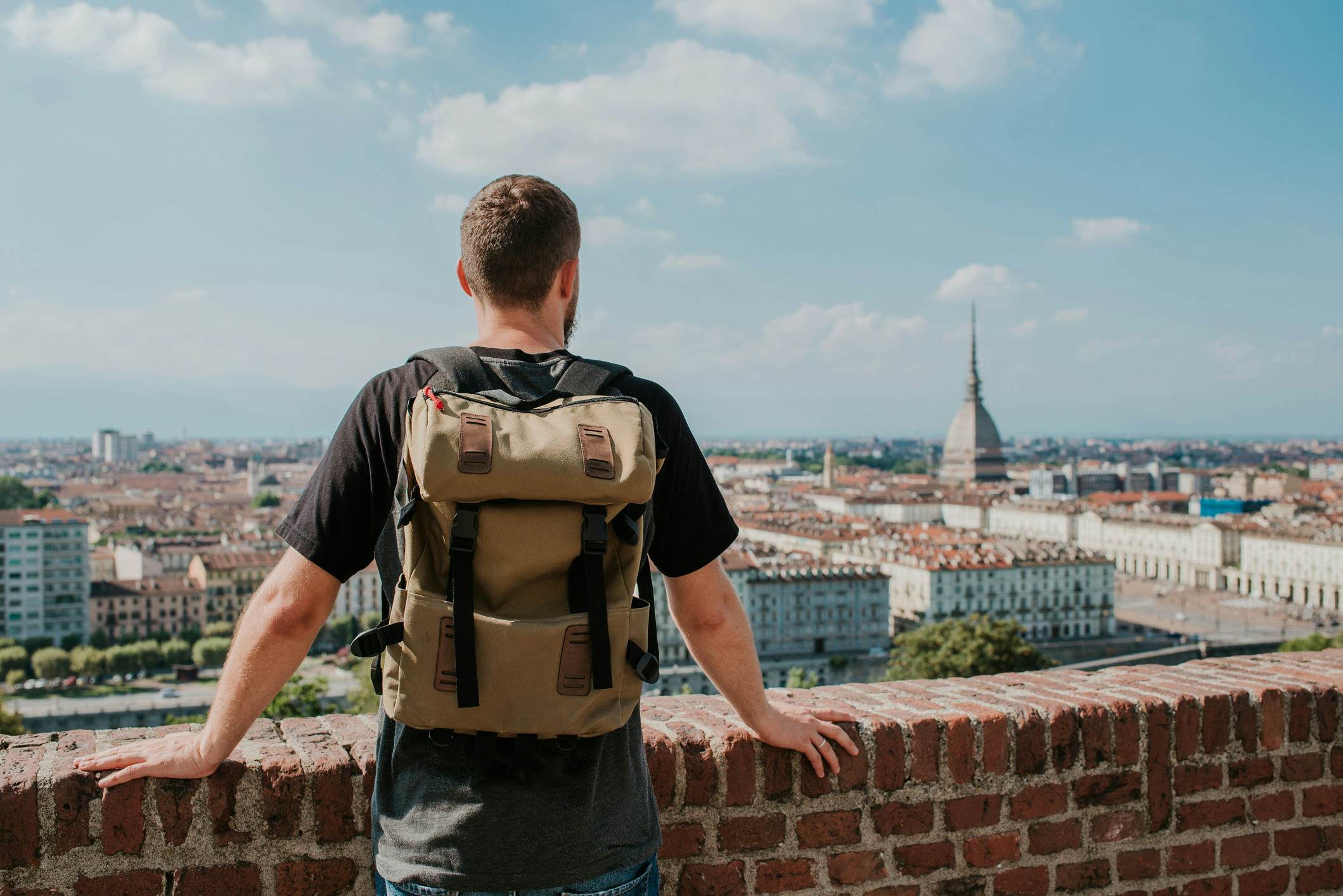 Man with backpack enjoy panorama of the Turin. Amazing scenic view on Mole Antonelliana